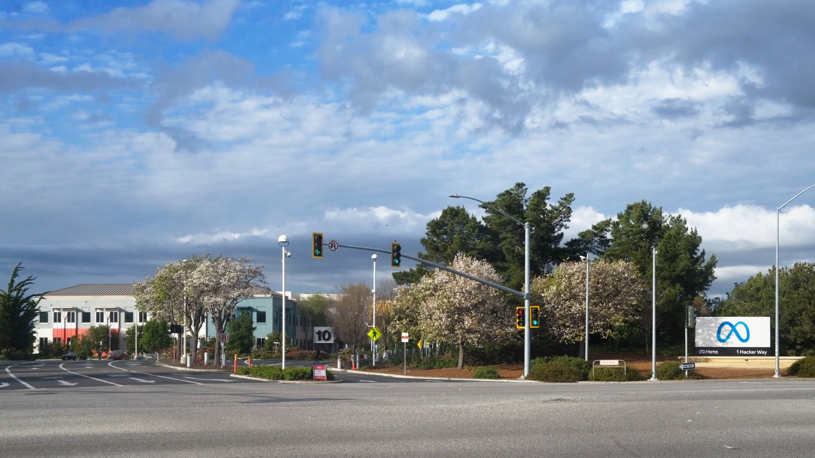 Entrada de la sede de Meta Platforms en Menlo Park, California, con el cartel del logotipo de Meta junto a la carretera.