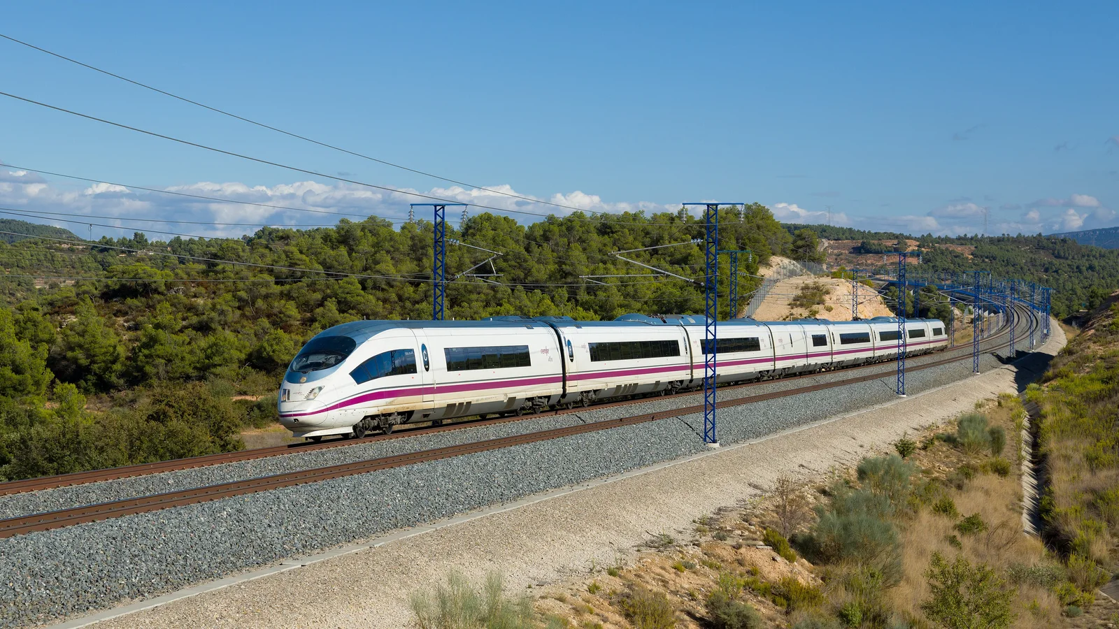 Tren AVE Velaro de la serie 103 de Renfe, fabricado por Siemens, circulando por la línea de alta velocidad Madrid-Barcelona entre encinas, cerca de Vinaixa (Lleida).